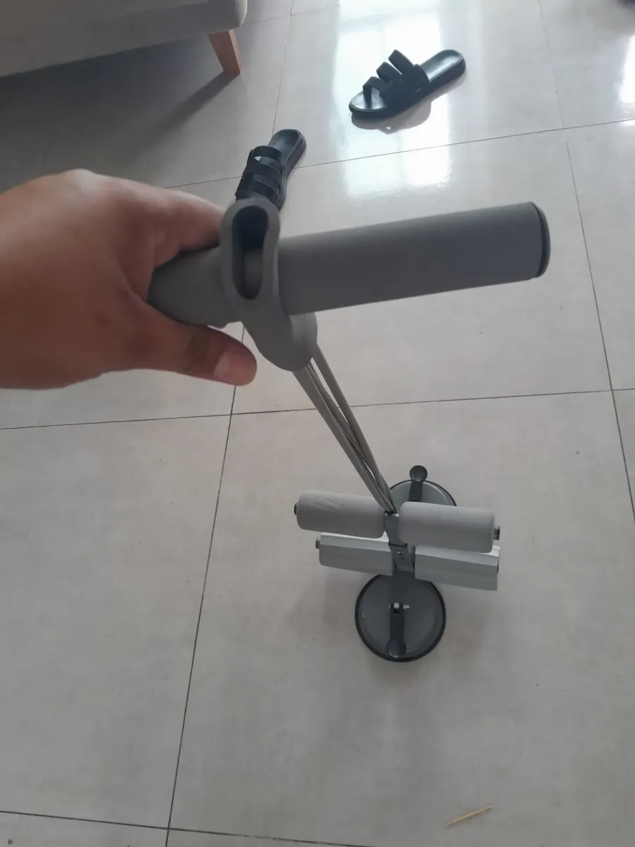 Mão segurando o puxador do aparelho de treino